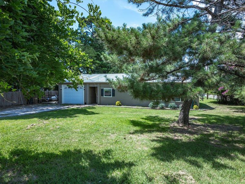 View of yard featuring an attached garage and driveway View of yard featuring an attached garage and driveway