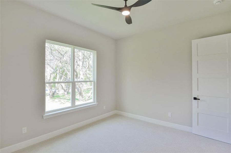 Unfurnished room featuring light colored carpet and ceiling fan Unfurnished room featuring light colored carpet and ceiling fan