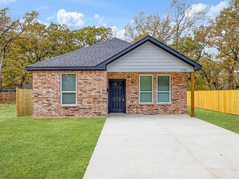 Single story home featuring brick siding, a shingled roof, and driveway