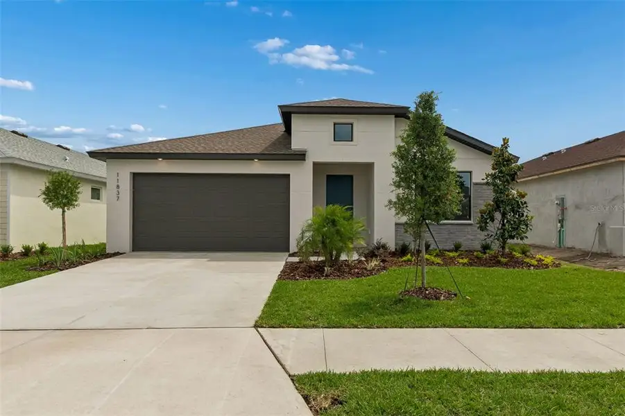 Front exterior of a new home in Isles at Bayview, Parrish, FL, highlighting curb appeal (Image 28). Front exterior of a new home in Isles at Bayview, Parrish, FL, highlighting curb appeal (Image 28).