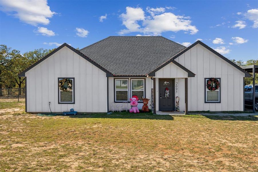 Modern farmhouse style home with a front yard