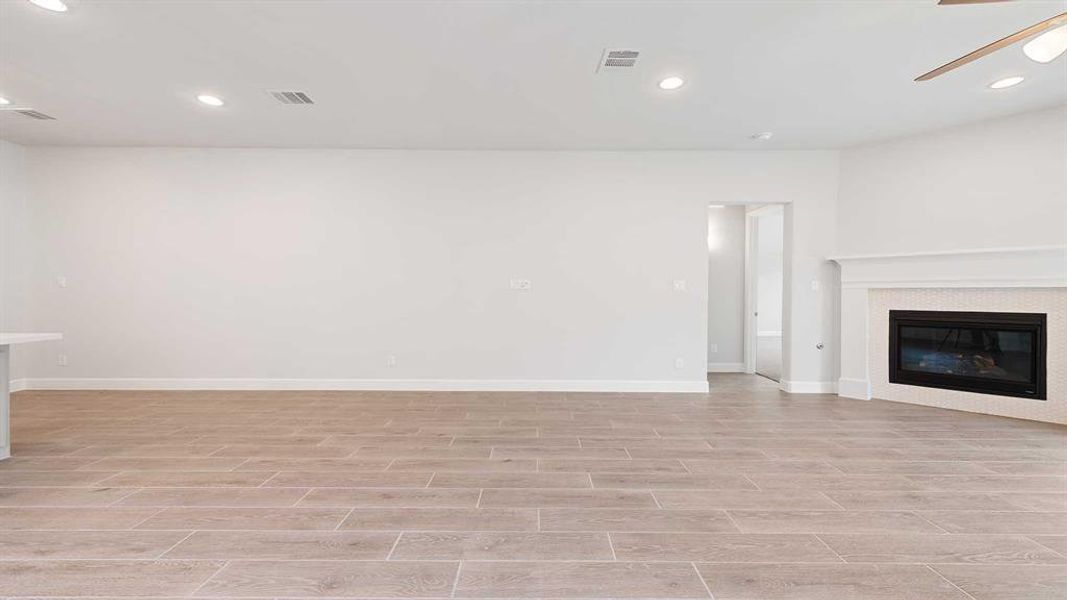 Unfurnished living room with ceiling fan and light wood-type flooring