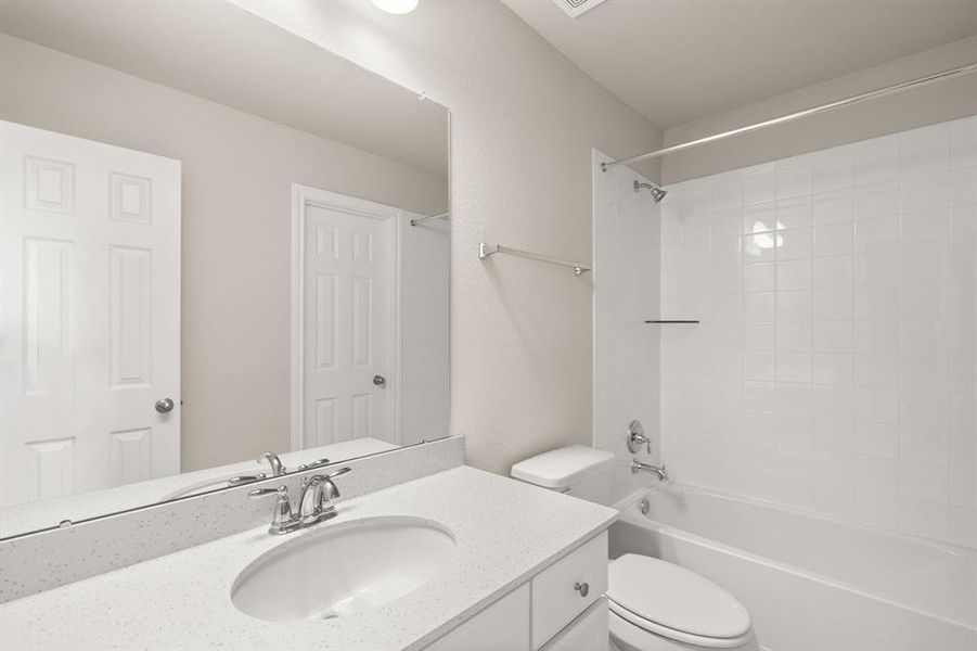 The secondary bath features tile flooring, white cabinetry and light countertops and a shower/tub combo. Perfect for accommodating any visiting family and friends.