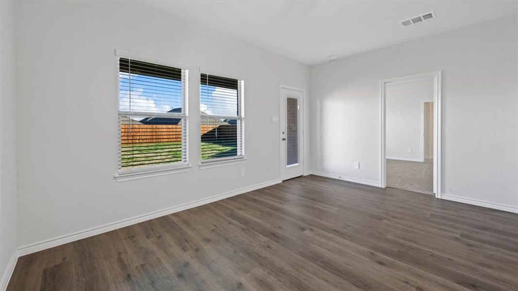 Empty room with dark wood-type flooring and baseboards Empty room with dark wood-type flooring and baseboards