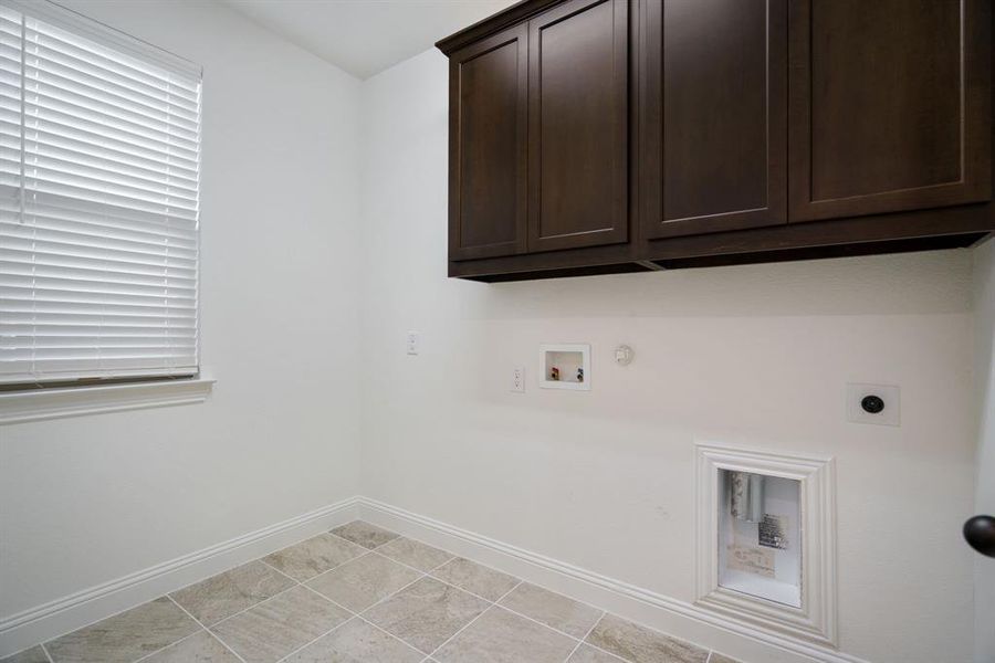The laundry room is both functional and tidy, thanks to added cabinets and room for a second refrigerator.