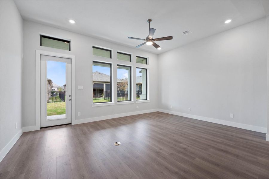 The great room features tall ceilings, ceiling fan, abundant natural light with plenty of windows, and an open, inviting ambiance--perfect for gatherings, relaxation, and making memories.