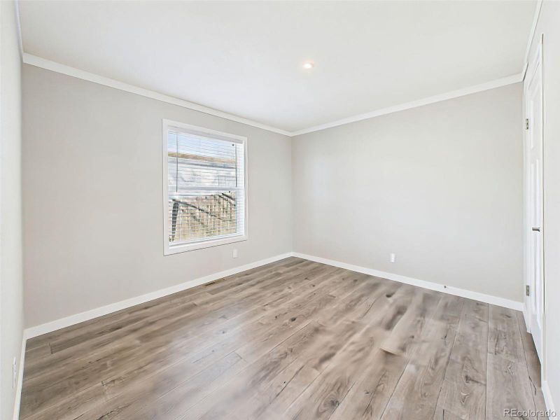 Unstaged Bedroom 3 View – Neutral tones, durable flooring, and a bright window create a versatile space ready to be personalized.