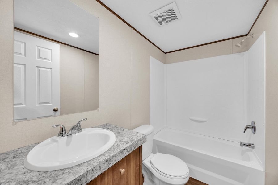 Bathroom featuring ornamental molding, shower / bathtub combination, vanity, and recessed lighting