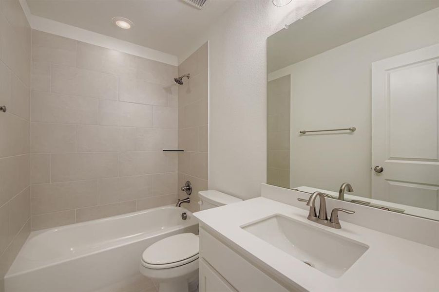 Bathroom with washtub / shower combination, vanity, and recessed lighting