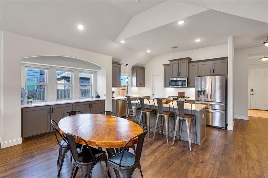 Dining room featuring vaulted ceiling and dark wood-type flooring