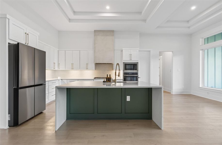 Designer kitchen features crisp white cabinetry, a contrasting island, stainless steel appliances, and generous workspace. **Images are from a previously completed project. **