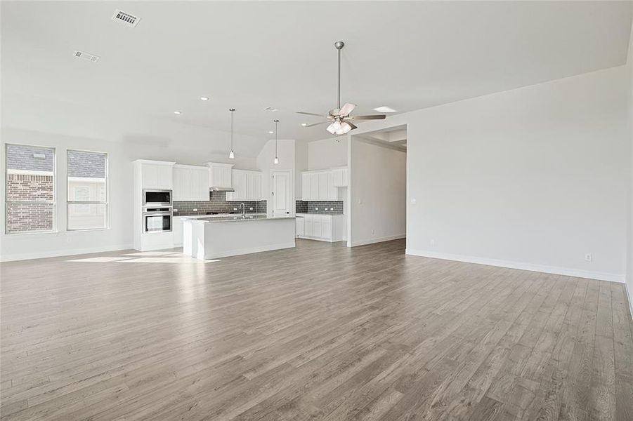 Unfurnished living room featuring light hardwood / wood-style floors, sink, and ceiling fan