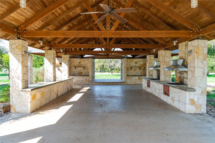 View of patio with a gazebo, a ceiling fan, an outdoor kitchen, and a fireplace