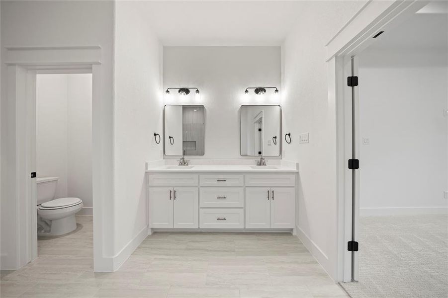 Full bath with double vanity and toilet