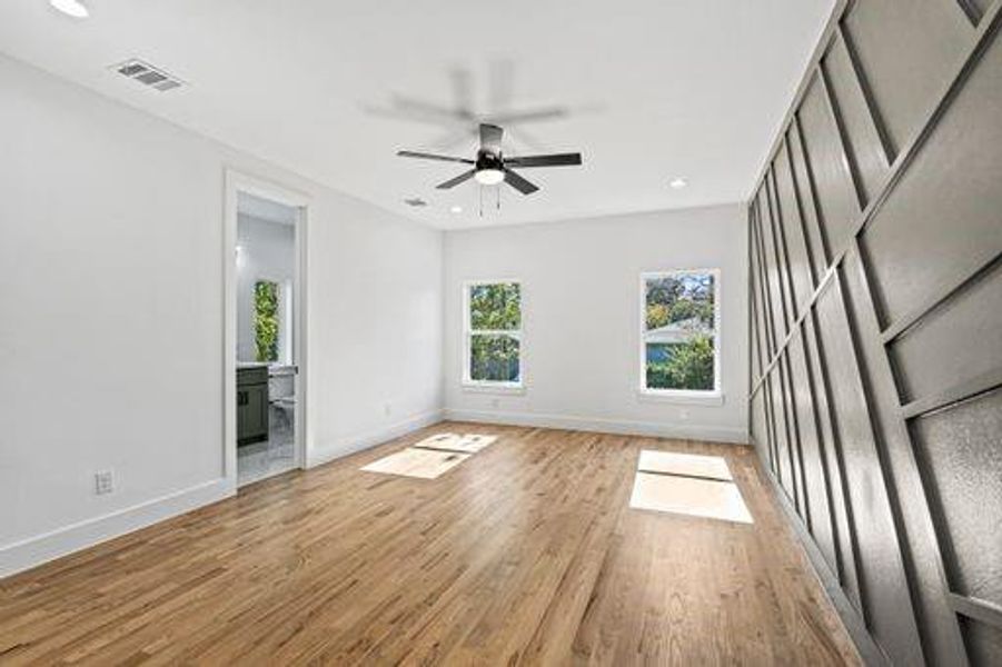 Empty room with ceiling fan and light wood-type flooring