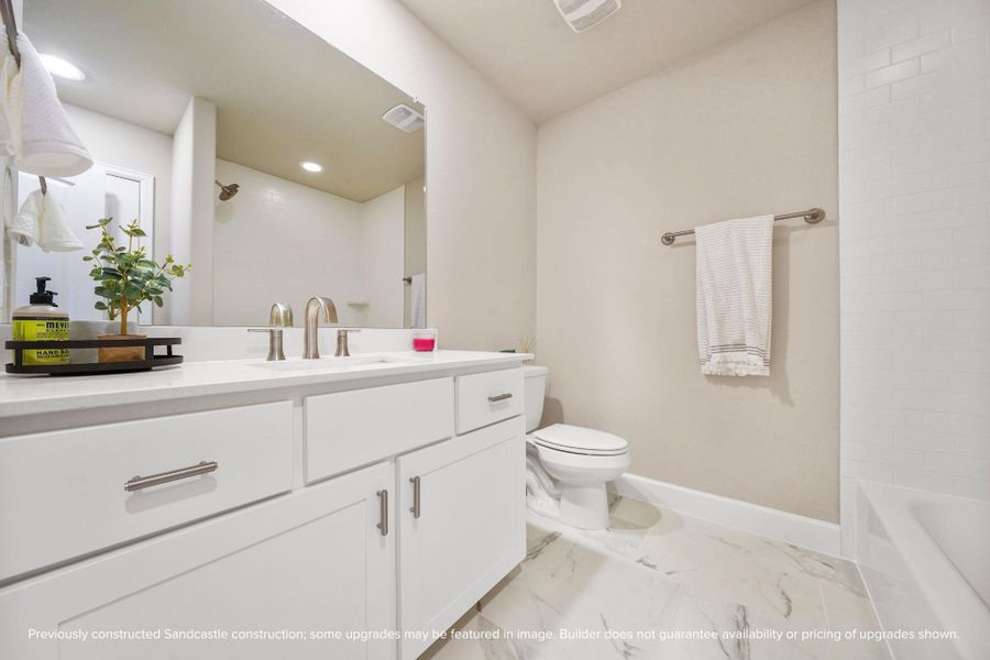 A polished, functional bath with quartz counters and fresh finishes that feel both classic and current.