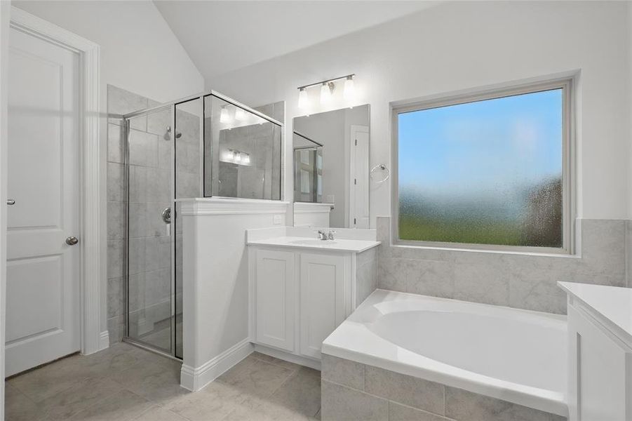 Full bathroom featuring vanity, a garden tub, a stall shower, and vaulted ceiling Full bathroom featuring vanity, a garden tub, a stall shower, and vaulted ceiling