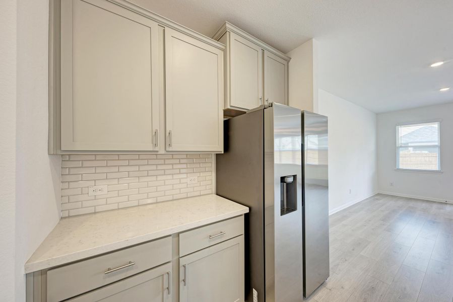 A well-appointed kitchen corner boasts sleek cabinetry and durable laminate flooring.