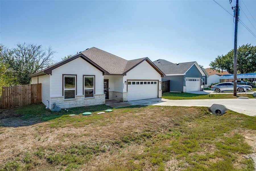 Single story home featuring stone siding, concrete driveway, roof with shingles, and an attached garage