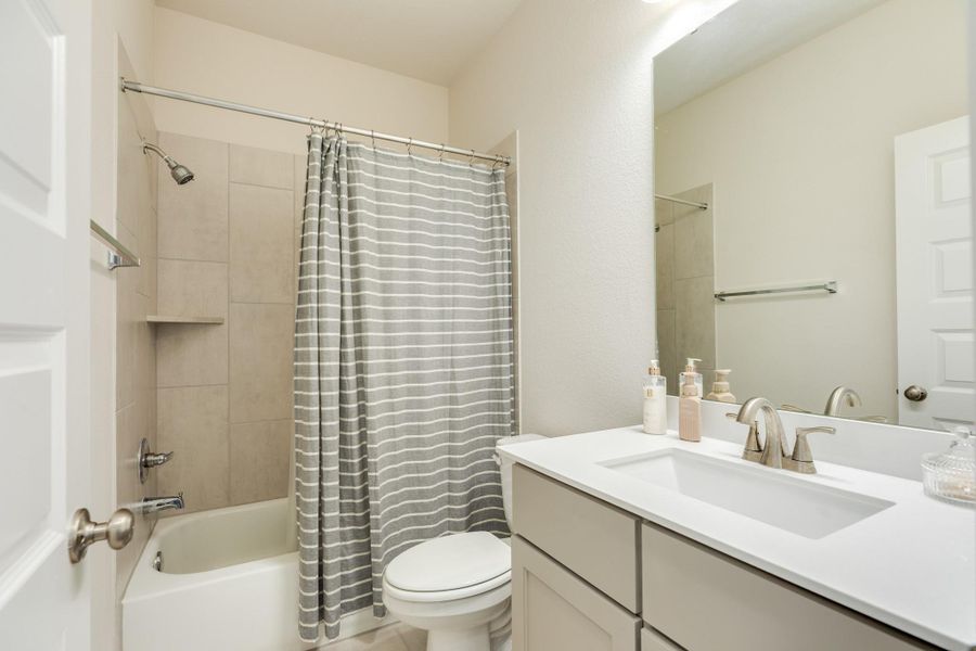 Hollywood-style bathroom upstairs featuring a functional tub/shower combo, elegant quartz countertops, and durable tile flooring; this spacious bathroom is conveniently shared between two bedrooms. Hollywood-style bathroom upstairs featuring a functional tub/shower combo, elegant quartz countertops, and durable tile flooring; this spacious bathroom is conveniently shared between two bedrooms.