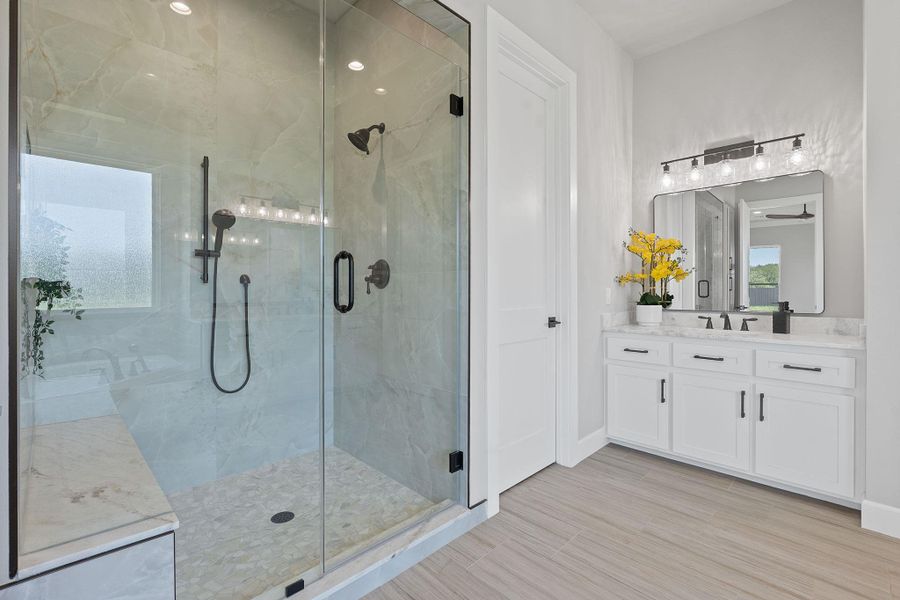 Full bathroom featuring a stall shower, vanity, and a ceiling fan