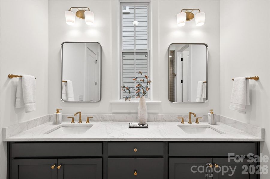 Primary Bath with quartz countertops and a fully frameless shower with a beautifully tiled shower floor.