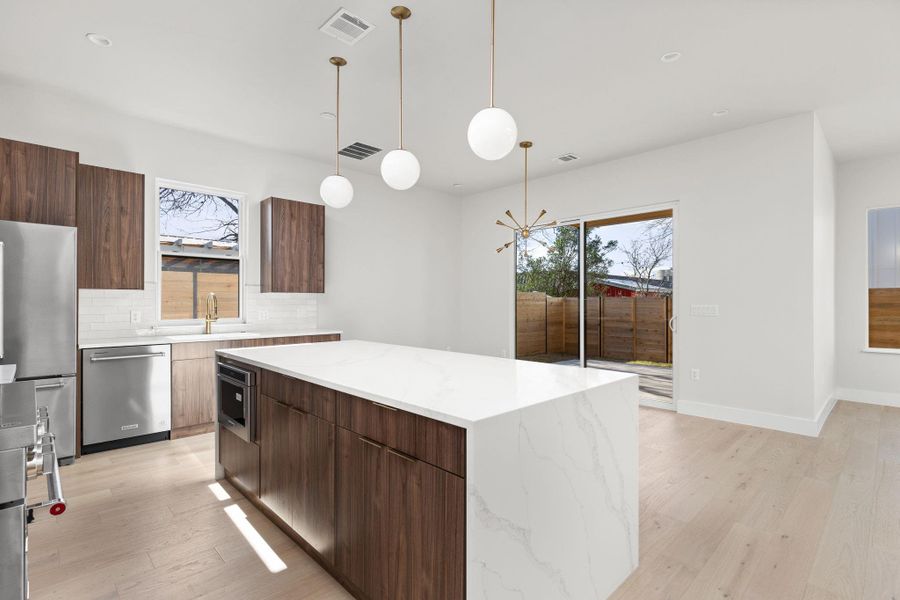 Kitchen featuring modern cabinets, visible vents, appliances with stainless steel finishes, and a kitchen island