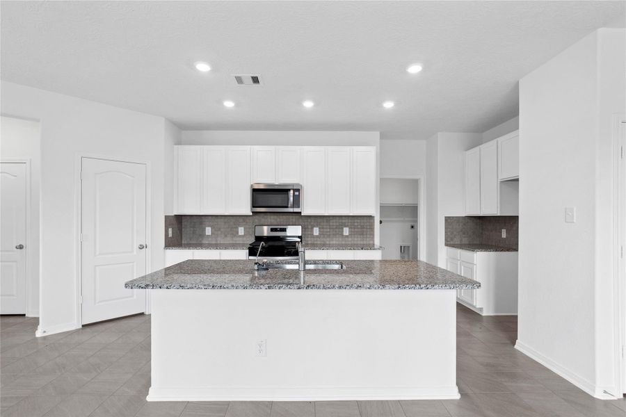 This spacious kitchen has it all—ample storage, generous counter space, and a layout that truly makes it the heart of the home.