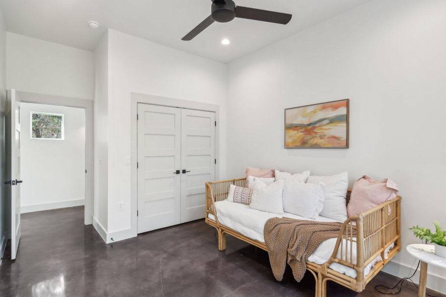 Living area featuring ceiling fan, concrete flooring, recessed lighting, and baseboards Living area featuring ceiling fan, concrete flooring, recessed lighting, and baseboards