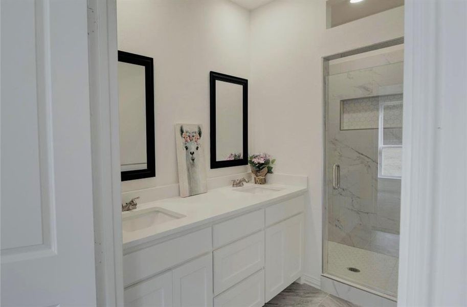 Bathroom with double vanity, a marble finish shower, and light marble finish flooring Bathroom with double vanity, a marble finish shower, and light marble finish flooring