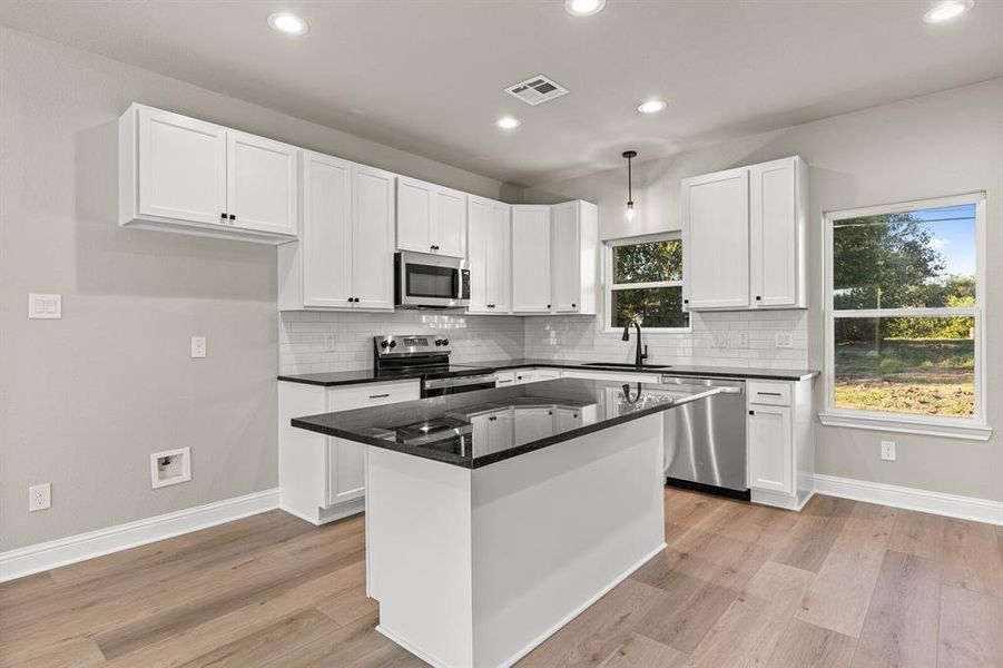Kitchen with white cabinets, appliances with stainless steel finishes, decorative backsplash, and recessed lighting Kitchen with white cabinets, appliances with stainless steel finishes, decorative backsplash, and recessed lighting