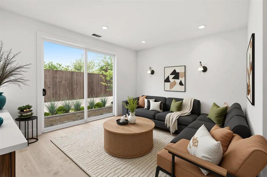 Living area featuring light-colored flooring, recessed lighting, and a sliding glass door providing natural light and views of the exterior