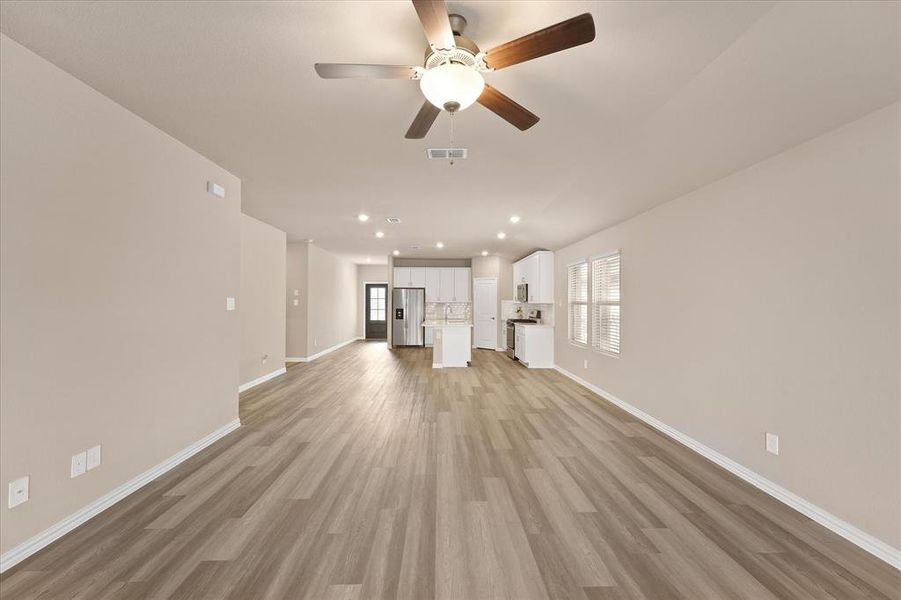 Unfurnished living room with light wood-type flooring, recessed lighting, and a ceiling fan Unfurnished living room with light wood-type flooring, recessed lighting, and a ceiling fan