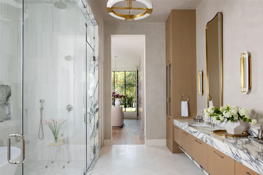 The spa-inspired bathroom showcases floating double vanities, marble floors, designer tile walls and ceilings, dual shower fixtures, a freestanding tub, and luxury marble countertops. The spa-inspired bathroom showcases floating double vanities, marble floors, designer tile walls and ceilings, dual shower fixtures, a freestanding tub, and luxury marble countertops.