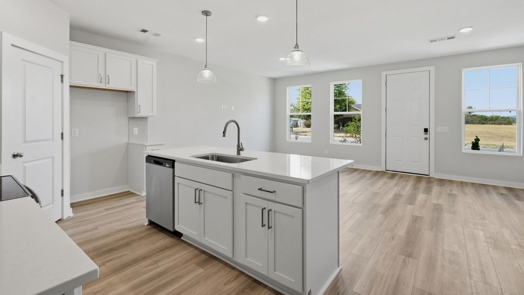 Kitchen island paired with sink and dishwasher with view of community