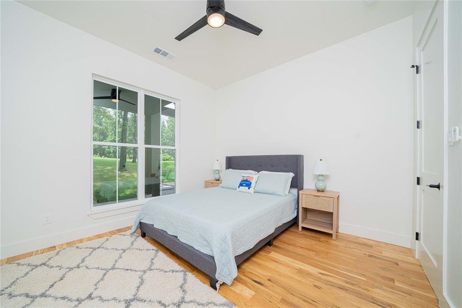 Bedroom with light wood-style floors and a ceiling fan Bedroom with light wood-style floors and a ceiling fan