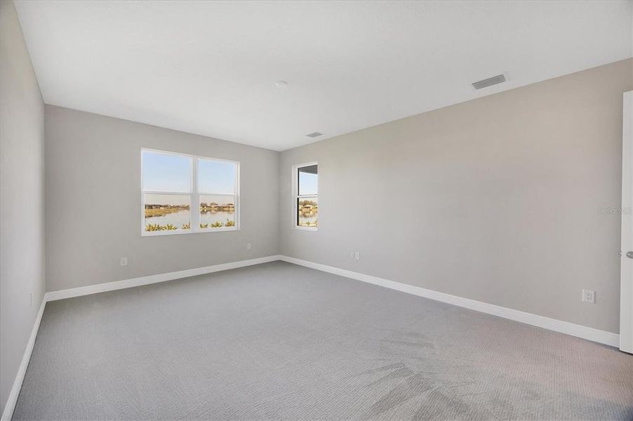 Primary bedroom with upgraded carpet and overlooking lake