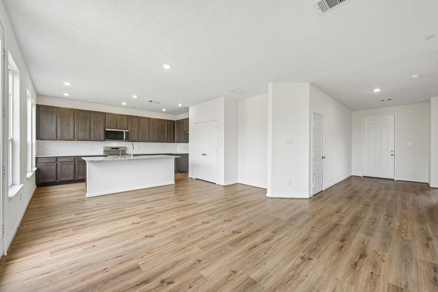 Create lasting memories around the table with family and friends in this inviting dining room! It showcases high ceilings, large window, access door to the backyard, vinyl plank flooring, and recessed lighting for a warm and welcoming atmosphere.