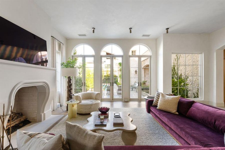 Living area featuring healthy amount of natural light, wood finished floors, and a fireplace with flush hearth