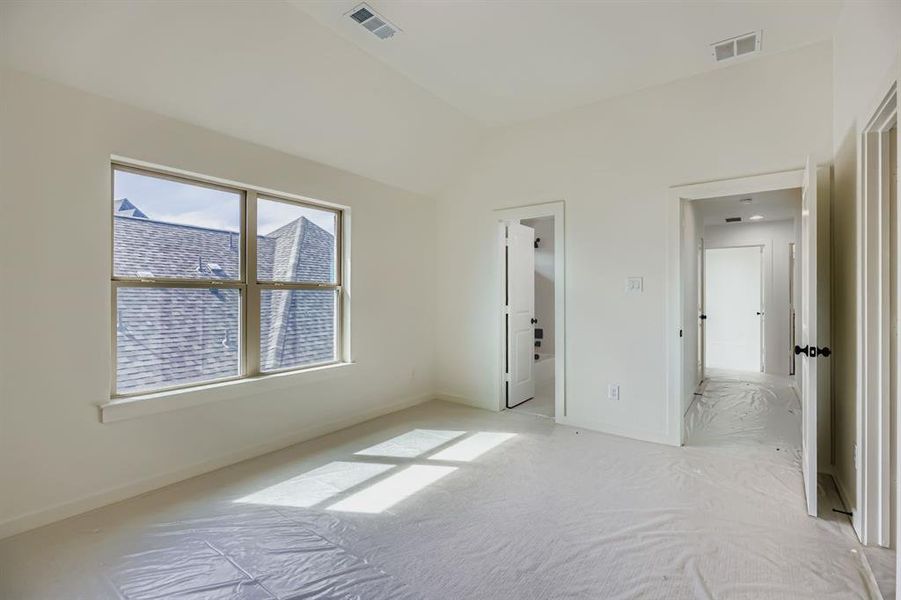 Unfurnished bedroom featuring carpet, lofted ceiling, and ensuite bath Unfurnished bedroom featuring carpet, lofted ceiling, and ensuite bath