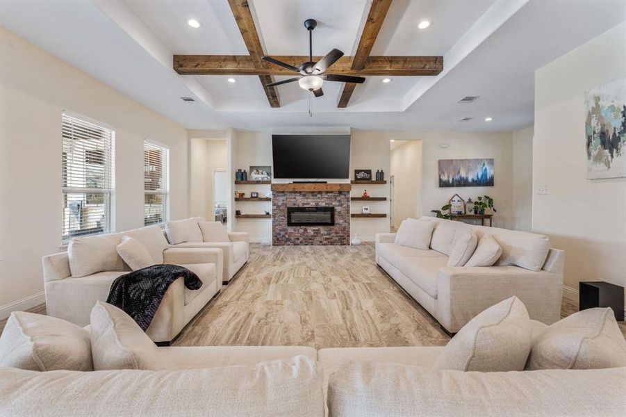 Living area with beamed ceiling, coffered ceiling, a glass covered fireplace, recessed lighting, and a ceiling fan Living area with beamed ceiling, coffered ceiling, a glass covered fireplace, recessed lighting, and a ceiling fan