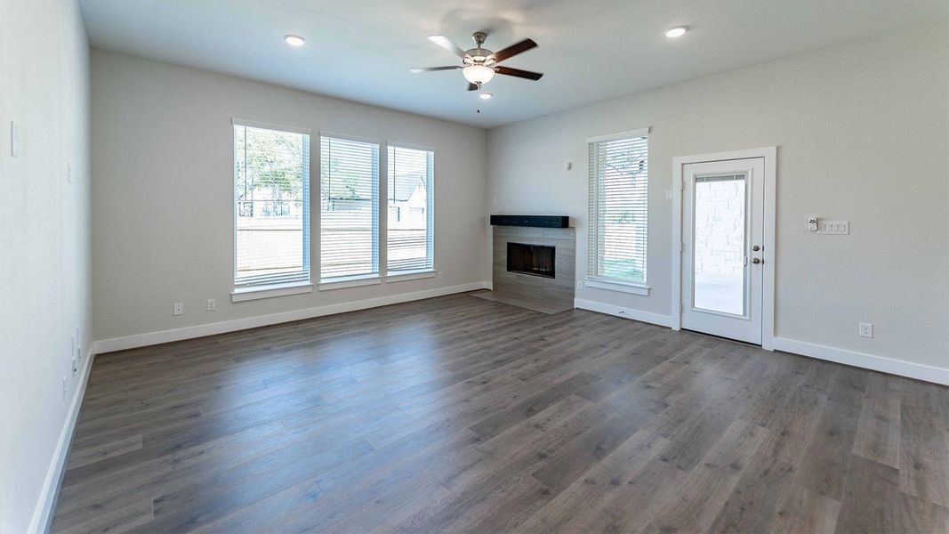 Unfurnished living room with a tile fireplace, dark wood finished floors, recessed lighting, and a ceiling fan Unfurnished living room with a tile fireplace, dark wood finished floors, recessed lighting, and a ceiling fan
