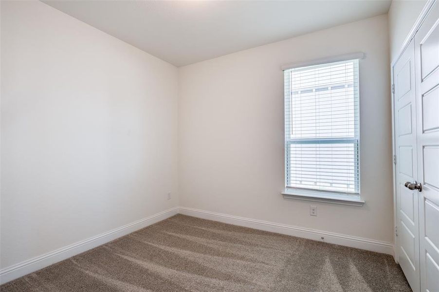 Spare room featuring carpet and baseboards