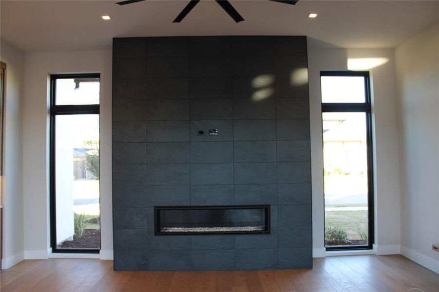 Foyer featuring a tile fireplace, light hardwood / wood-style flooring, and ceiling fan