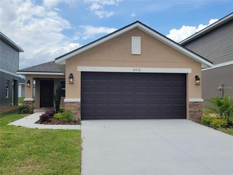 Front exterior of a new home in Highland Hills, Hudson, FL, highlighting curb appeal (Image 12).