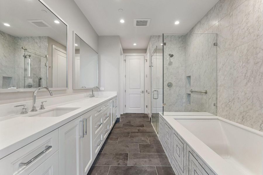 Transform your own primary bathroom into an at home-spa. An oasis complete with soaking tub, framed with designers decorative tile,  a seamless walk-in glass shower, an expansive double vanities featuring generous counter space, a linen closet and a door leads to a private water-closet.