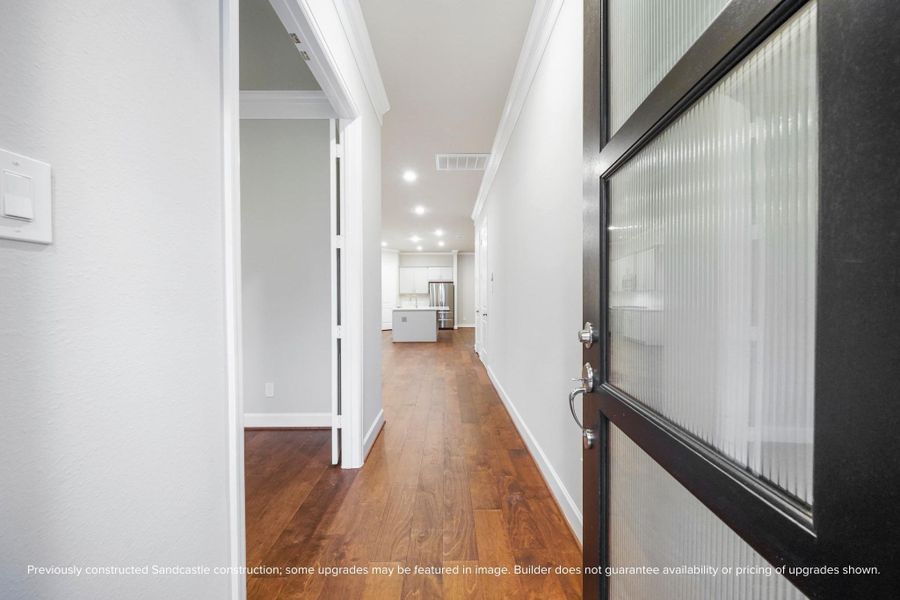 Step inside and feel the flow—this airy entry sets the tone with clean lines, warm flooring, and a path that draws you straight into the home’s vibrant core.