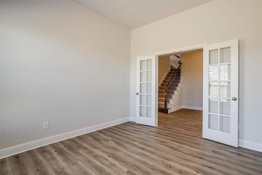 Spare room featuring french doors and hardwood / wood-style floors