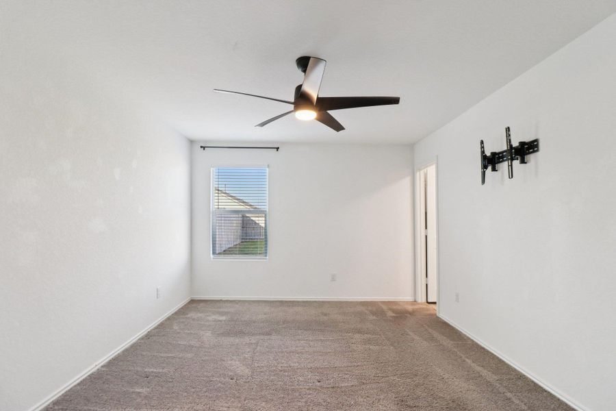 Carpeted spare room with ceiling fan