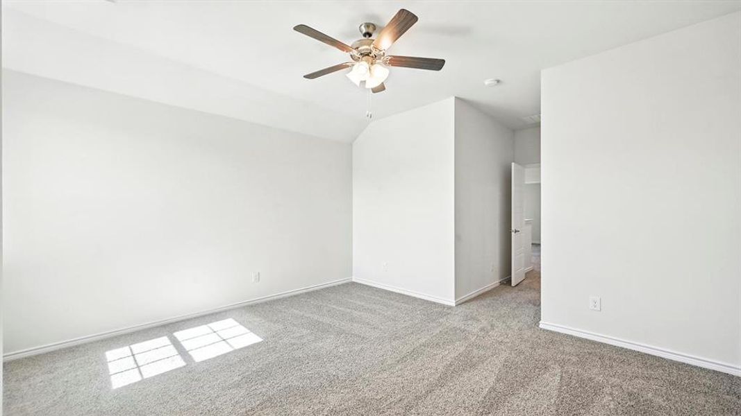 Unfurnished bedroom with carpet, ceiling fan, and lofted ceiling